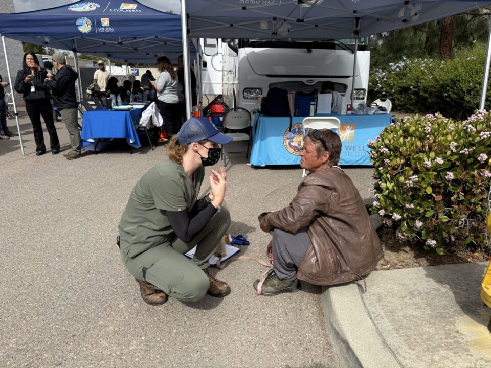 Woman speaking with a person experiencing homelessness at outreach event