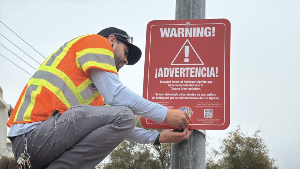 worker putting up warning sign