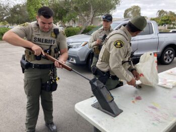 a deputy inspecting a rifle