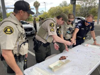 law enforcement inspect a gun at a table