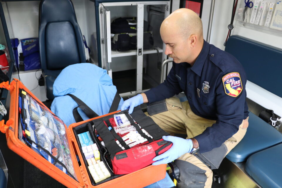 Paramedic sitting in an ambulance checking medical gear