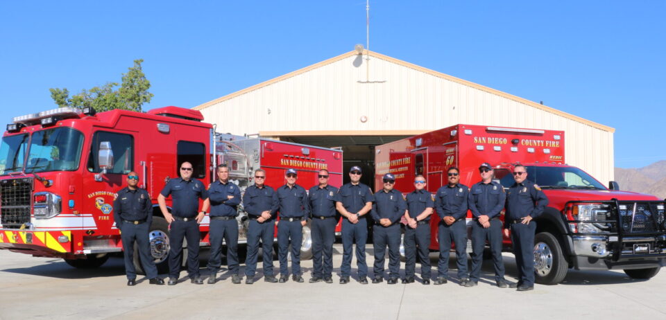 Crew of CAL FIRE Station 60 in Borrego Springs standing in front of a fire truck and ambulance