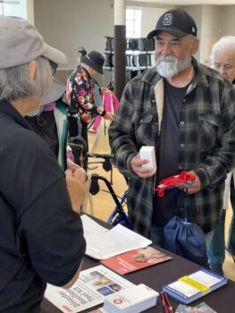 Man speaks to woman at a table 