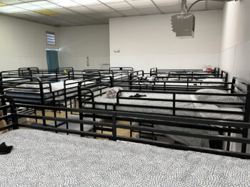 a room with many made up bunkbeds