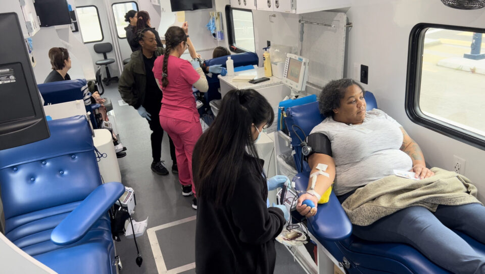 woman giving blood in blood bank bus
