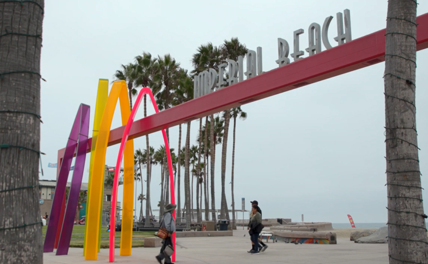People walking near the Imperial beach Sign