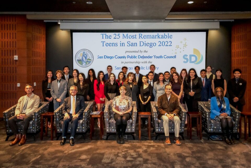 Large group photo in front of screen with "25 Most Remarkable Teens in San Diego 2022"