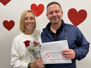 Couple holds marriage license and smiles