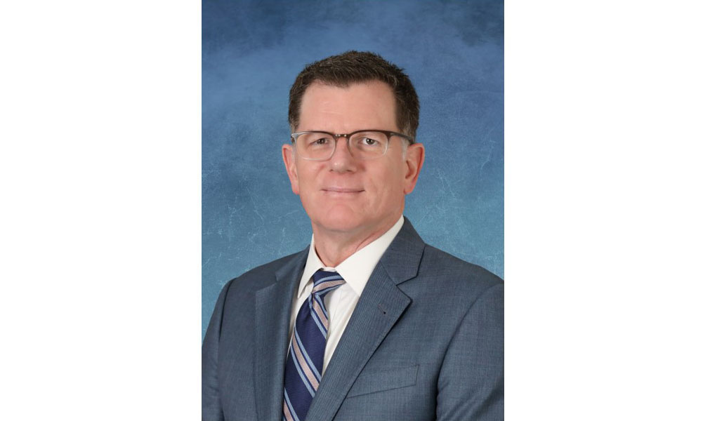 Dr. Lucas smiles in suit