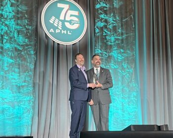 2 men onstage posing with award