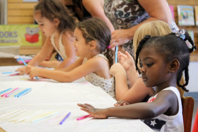 Children reading at table in library