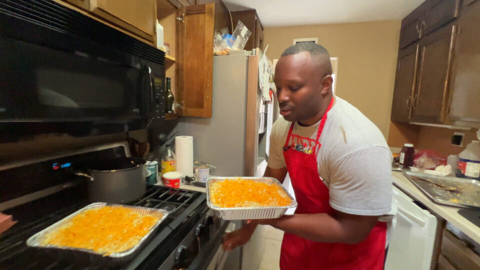 Man making macaroni and cheese in home kitchen