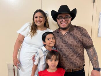 Couple and two young children smile close together