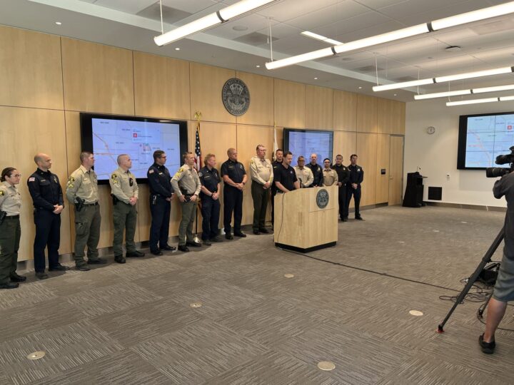 officials stand being podium in open room