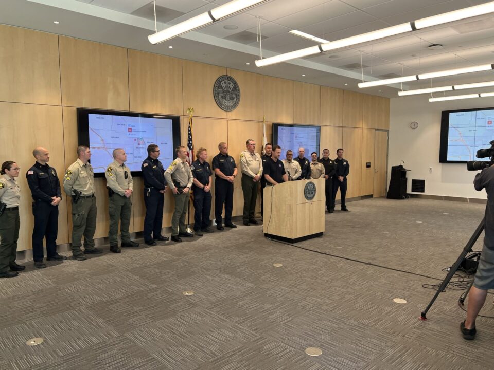 officials stand being podium in open room