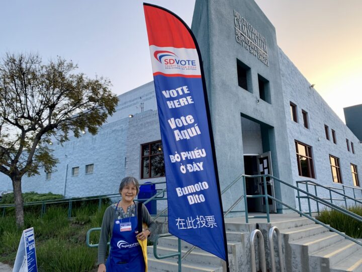 A Poll worker standing in front of a vote center.