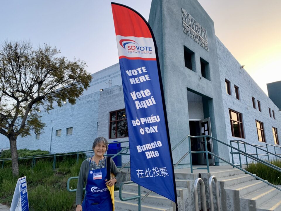 A Poll worker standing in front of a vote center.