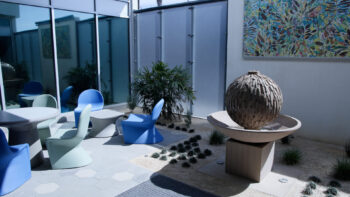 pretty round fountain with tables and chairs outdoors