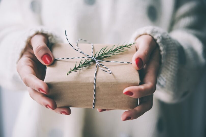 someone with painted nails holds small wrapped gift