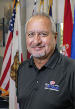 Smiling man in front of flags