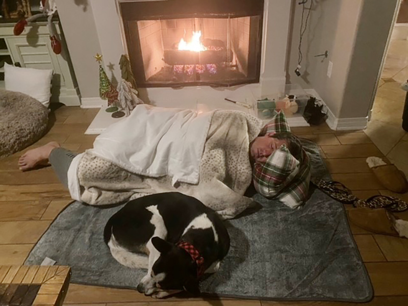 Man sleeping on floor with new dog in living room