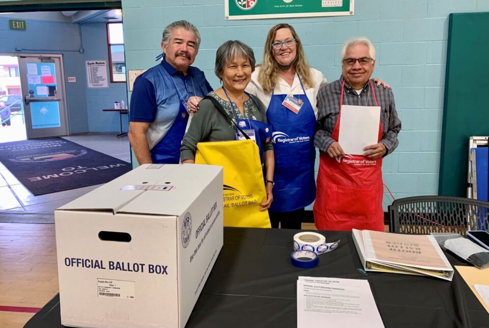 people stand behind official ballot box