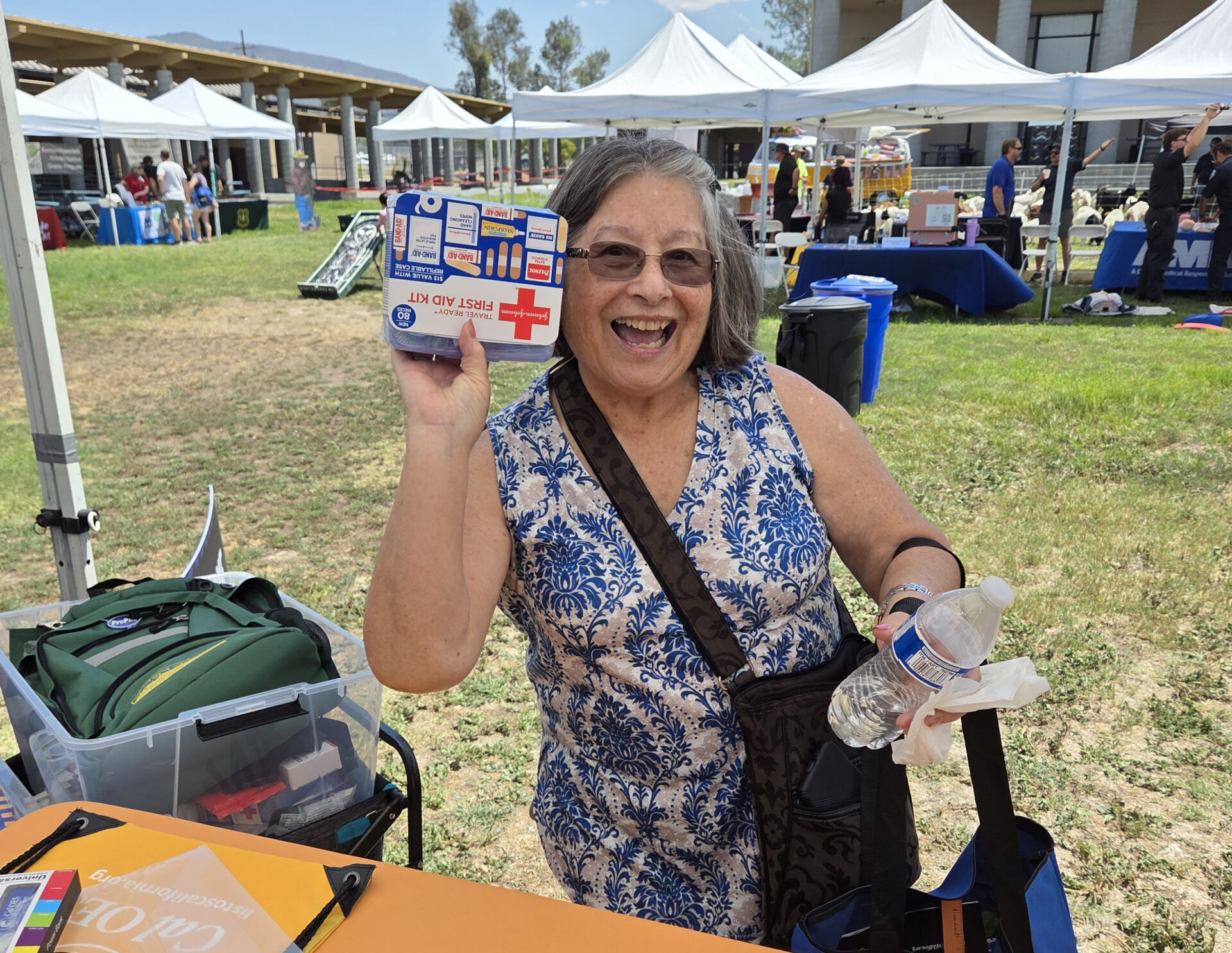 Smiling woman holding first aid kit up