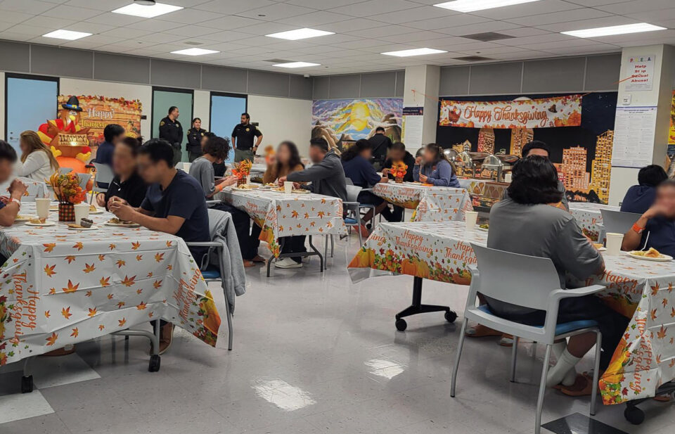 People eating at tables decorated with Thanksgiving tablecloths