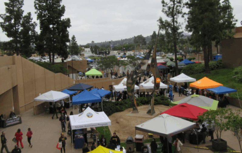 many pop-up tents in an open plaza with many people
