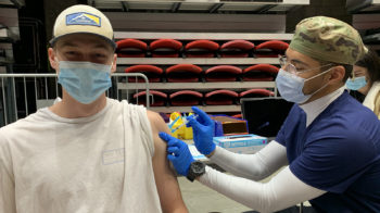 a young man gets a vaccine