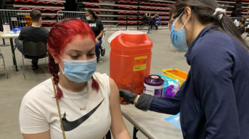 a young woman gets a vaccine