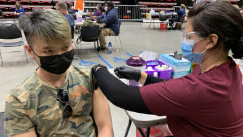 a young man gets a vaccine