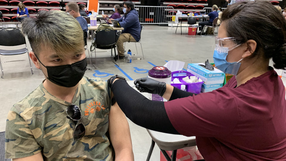 a young man gets a vaccine