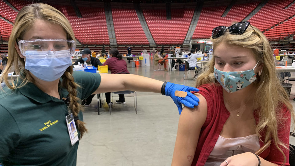 a young woman gets a vaccination