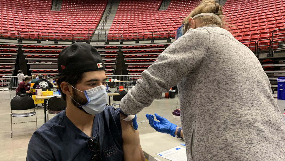a young man gets a vaccine