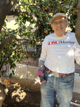 Senior volunteer in front of fruit tree