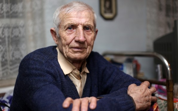 older person crossing arms at table