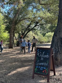 Gramping sign with ranger and group on hike