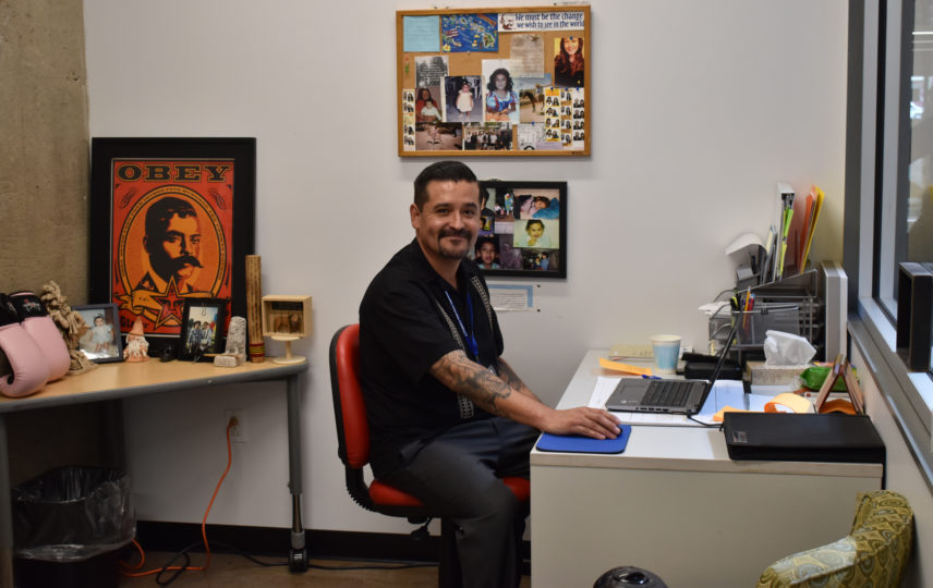 Social worker man sitting at his desk at Achievement Center for youth.