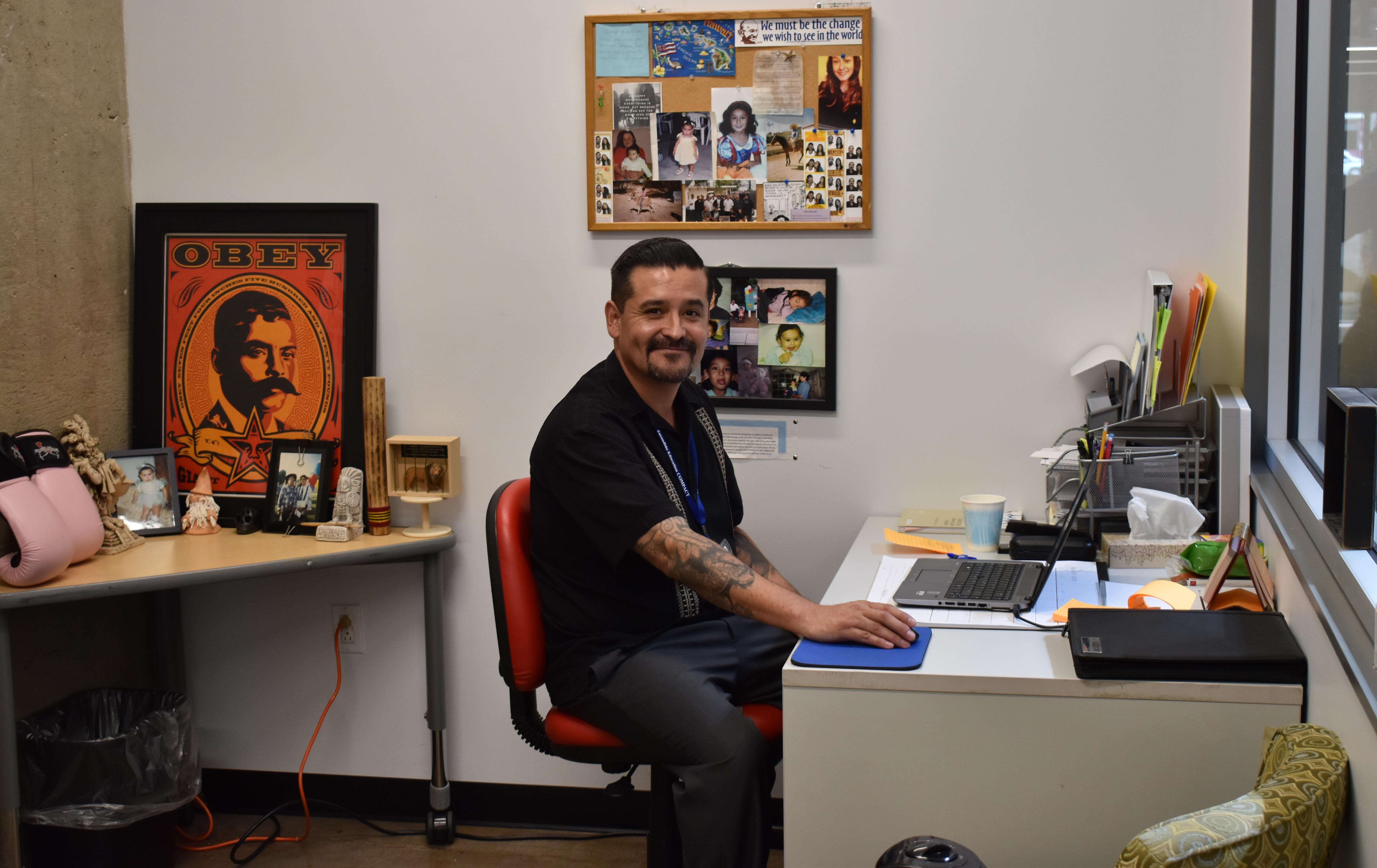 Social worker man sitting at his desk at Achievement Center for youth.