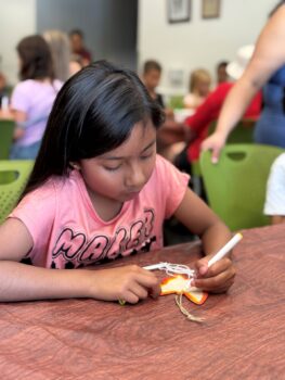 Girl coloring a butterfly as part of making crafts at the Library