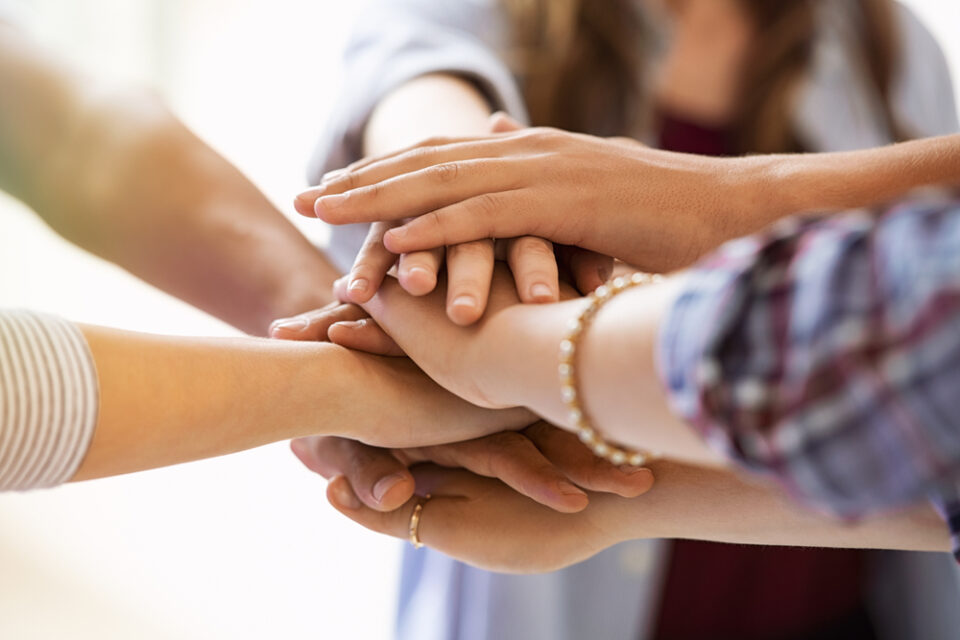Group of hands on top of each other like huddle.