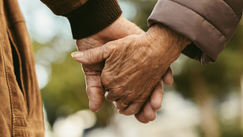 Elderly people holding hands