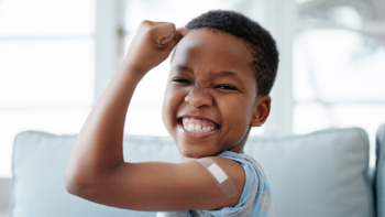 kid smiling with bandaid