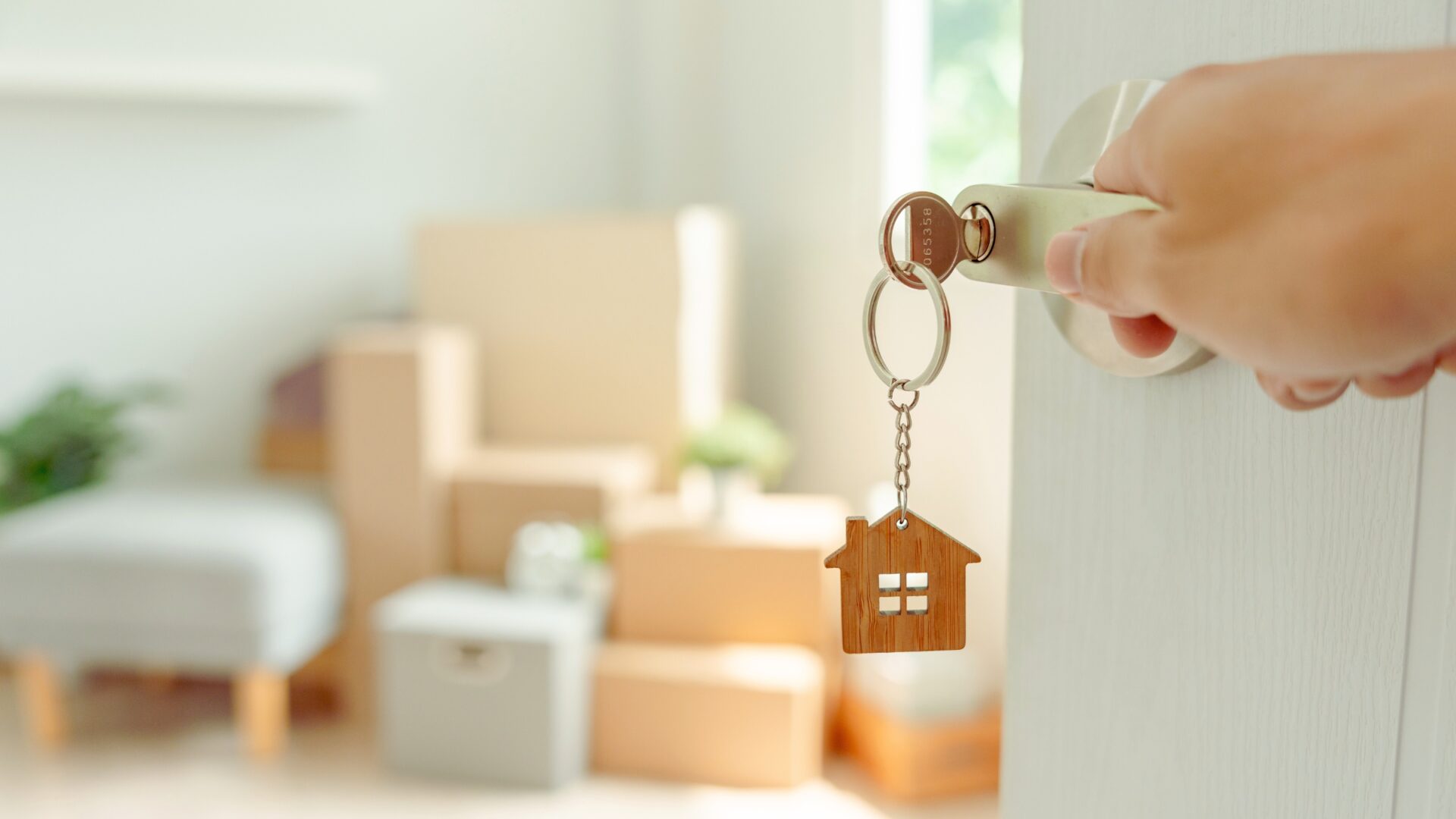 hand on open door with moving boxes
