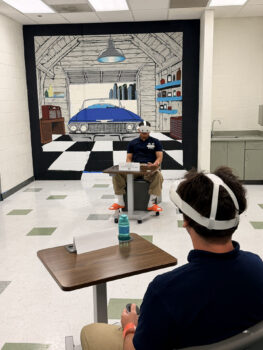 Young men wearing VR headsets to learn auto repair