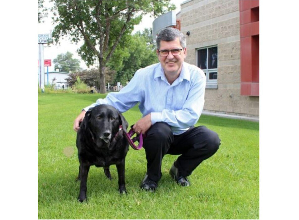 person and dog on grass outside building