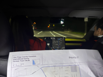 a person sitting in the back seat of a car holds up a map