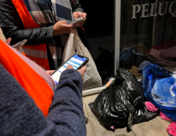 volunteers speaks with a person experiencing homelessness