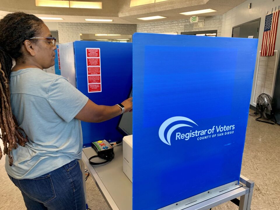 person stands at voting machine